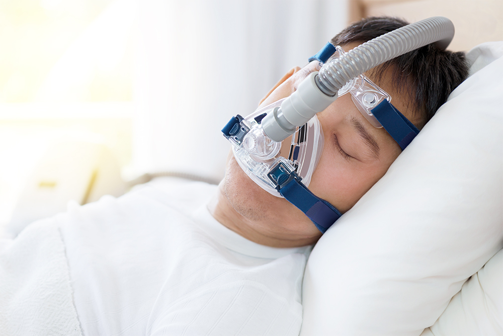 Ein Patient schläft komfortabel mit einer CPAP-Maske, die von Medtek zur Behandlung von Schlafapnoe und für einen erholsamen Schlaf bereitgestellt wird. Dieses Bild illustriert die effektive Schlafapnoe-Therapie.